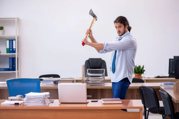 Ofiste elinde baltayla dolaşan öfkeli genç bir erkek. — Stok fotoğraf