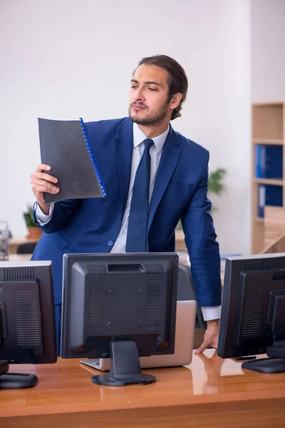 Mladý muž zaměstnanec v konceptu multitasking — Stock fotografie