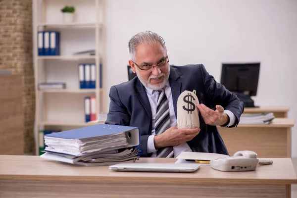 Aged businessman employee holding moneybag in the office — Stock Photo, Image