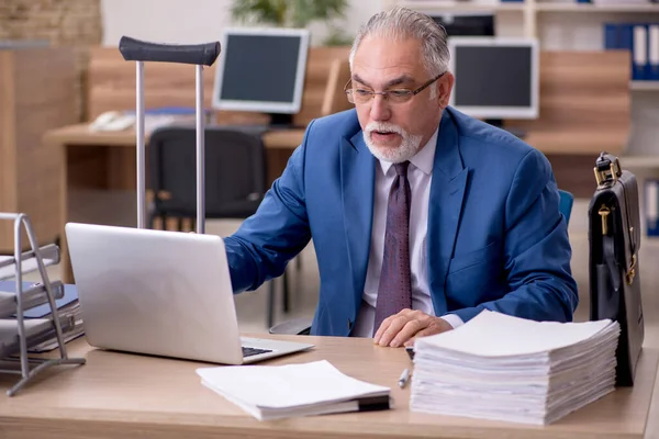 Vecchio impiegato uomo d'affari dopo l'infortunio che lavora in ufficio — Foto Stock