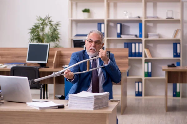 Gammal affärsman anställd efter olycka arbetar på kontoret — Stockfoto