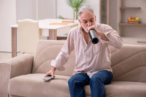 Staruszek pijący alkohol w domu — Zdjęcie stockowe