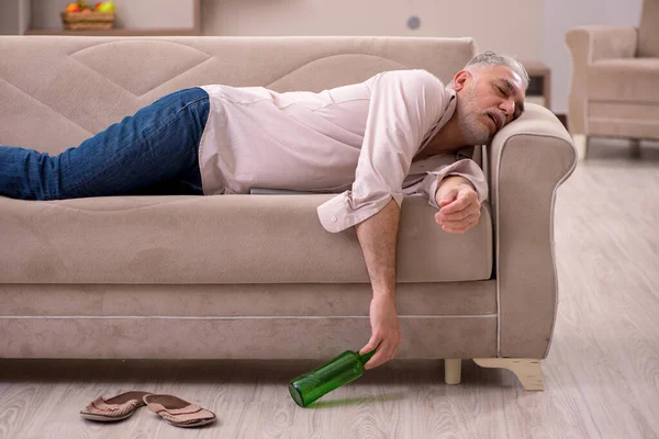 Vieil homme buvant de l'alcool à la maison — Photo