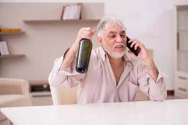 Velho bebendo álcool em casa — Fotografia de Stock