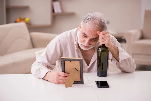 Velho viúvo bebendo álcool em casa — Fotografia de Stock