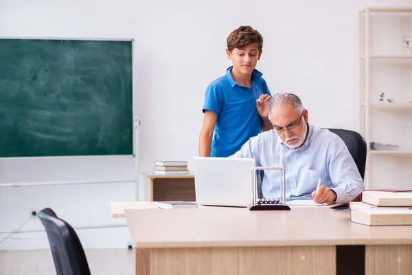 Old male teacher and schoolboy in the classroom — Stock Photo, Image