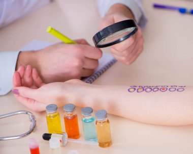 Hastanedeki hastanın alerji reaksiyonunu test eden doktor.