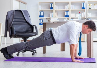 İş adamı ofisinde spor yapıyor.