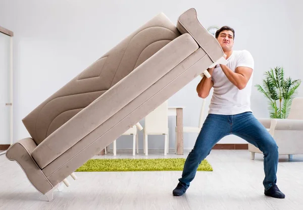 Hombre joven moviendo muebles en casa — Foto de Stock