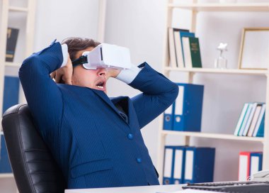 Çalışan ofiste sanal gerçeklik gözlüğü kullanıyor.