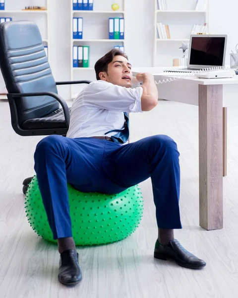 Joven empresario haciendo deporte estiramiento en el lugar de trabajo — Foto de Stock