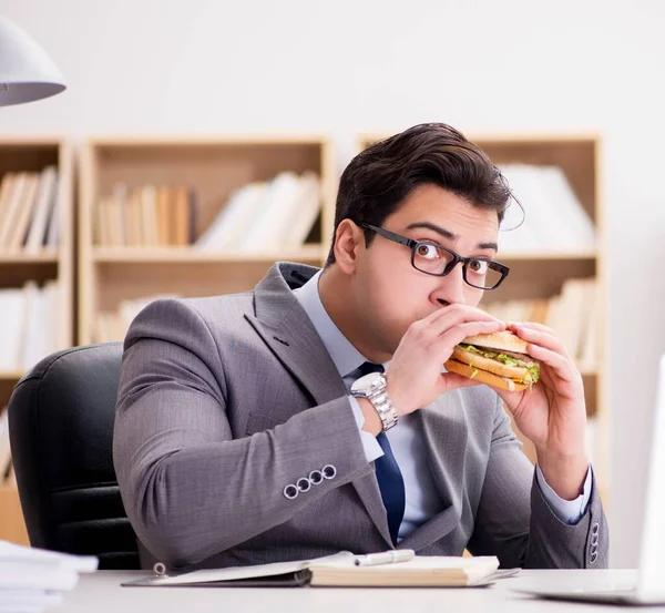 Hungrig rolig affärsman äter skräpmat smörgås — Stockfoto