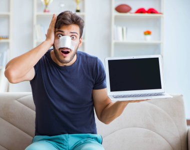 Genç adam estetik cerrahi burnundan sonra evde iyileşiyor.