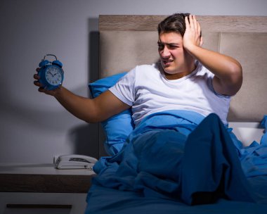 Adam yatakta uyumakta zorlanıyor.