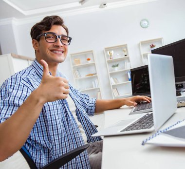 Birçok ekranın önünde oturan bir iş adamı