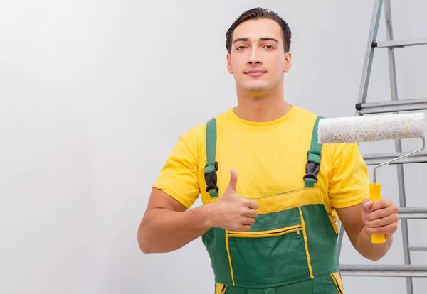 Uomo che dipinge il muro nel concetto di fai da te — Foto Stock