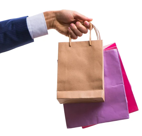 Mão segurando sacos de compras com compras de Natal na parte traseira branca — Fotografia de Stock