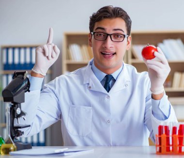 Bilim adamı organik meyve ve sebzeler üzerinde çalışıyor.