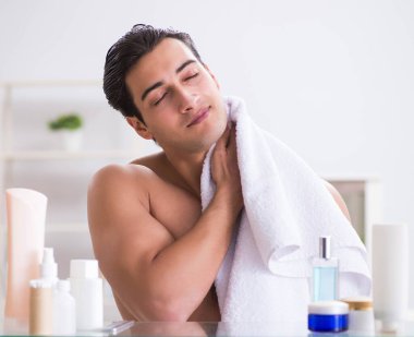 Genç adam banyoda çalışmak için hazırlanıyor.