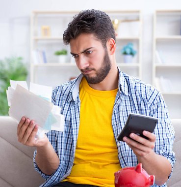 Ödeme yapması gereken faturalara kızgın bir adam.