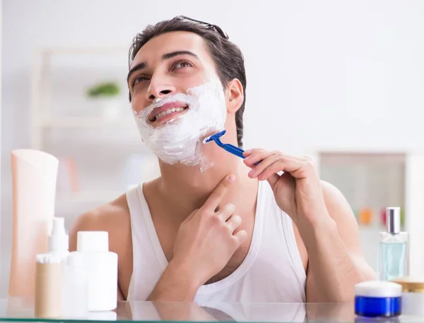 Giovane uomo bello rasatura la mattina presto a casa — Foto Stock