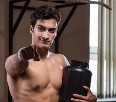 Spor salonunda besin takviyesi olan bir adam.