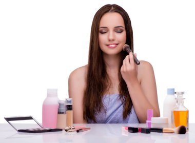 Beyazlar içinde makyaj yapan kadın.