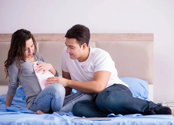 Familia joven con esposa embarazada esperando al bebé en la cama — Foto de Stock