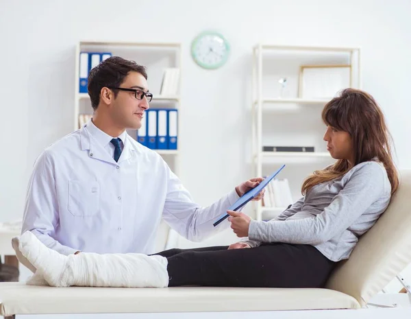 Läkare undersöker patient med brutet ben — Stockfoto