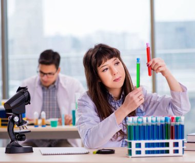 Laboratuvarda deney yapan iki kimyager.