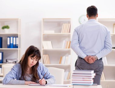 Erkek öğretim görevlisi bayan öğrenciye ders veriyor.