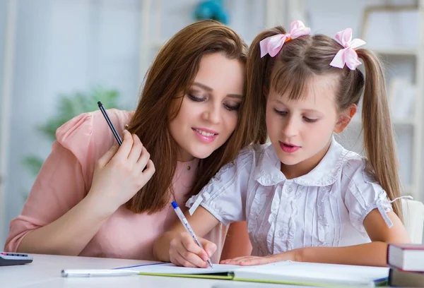 Mother helping her daughter to do homework — Stock Photo, Image