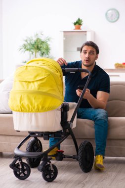 Genç baba yeni doğan bebeğe bakıyor.