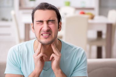 Genç adam boğaz ağrısı çekiyor.