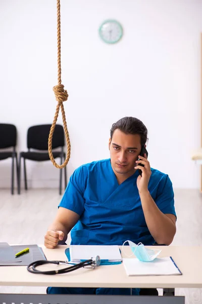 Young male doctor committing suicide at workplace — Stock Photo, Image
