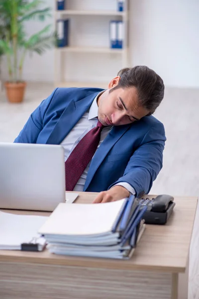 Jovem funcionário masculino infeliz com excesso de trabalho no escritório — Fotografia de Stock