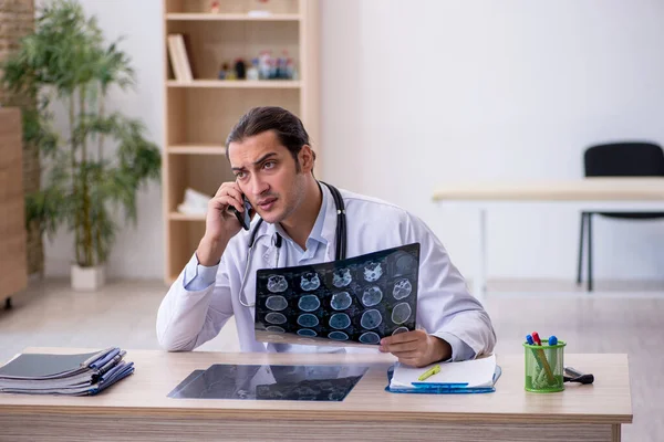 Ung manlig röntgenläkare som arbetar på kliniken — Stockfoto