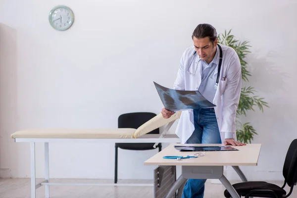 Ung manlig röntgenläkare som arbetar på kliniken — Stockfoto