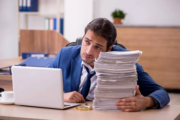 Jovem funcionário masculino infeliz com excesso de trabalho no escritório — Fotografia de Stock