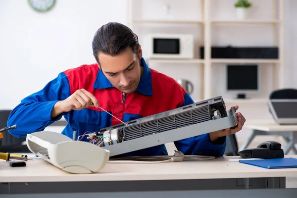 Молодий ремонтник ремонтує кондиціонер в гарантійному центрі — стокове фото