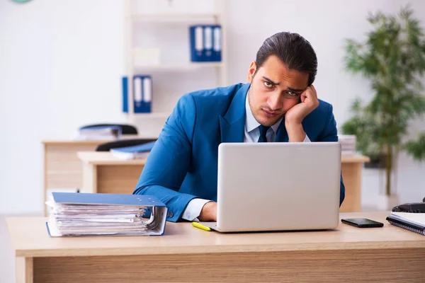 Young businessman employee unhappy with excessive work in the of — Stock Photo, Image