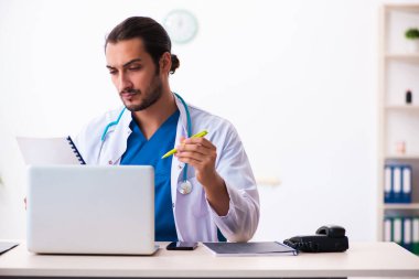 Klinikte çalışan genç erkek doktor.