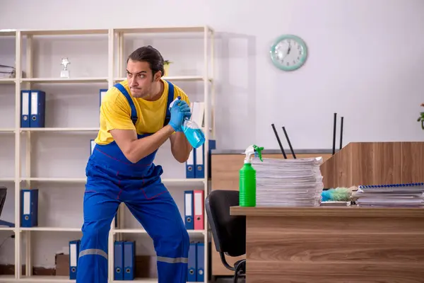 Joven contratista masculino limpiando la oficina — Foto de Stock