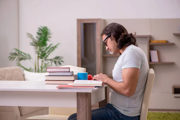 Jovem estudante do sexo masculino se preparando para exames em casa — Fotografia de Stock