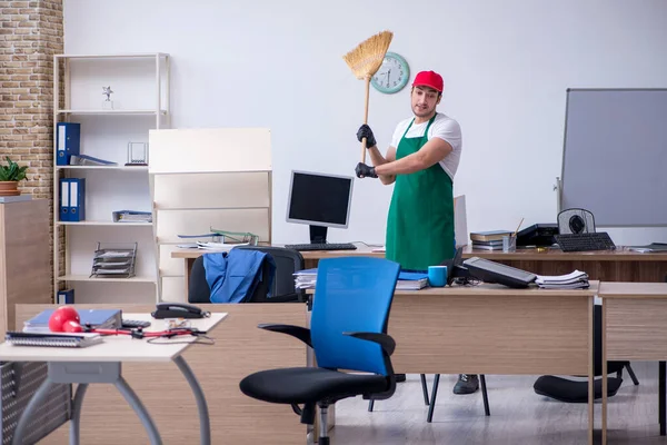 Joven contratista masculino limpiando la oficina — Foto de Stock