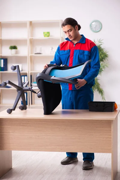 Joven contratista reparando muebles en la oficina — Foto de Stock