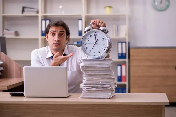 Νεαρός άνδρας υπάλληλος στην έννοια διαχείρισης του χρόνου στο γραφείο — Φωτογραφία Αρχείου