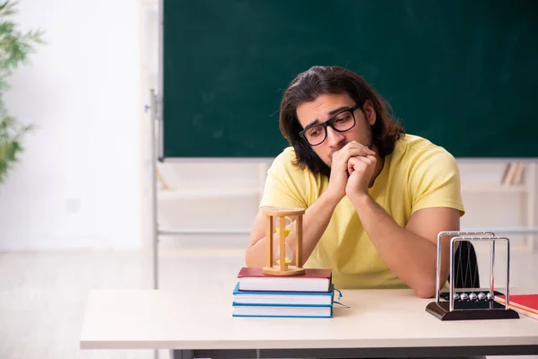 Jonge mannelijke student natuurkundige voorbereiding voor examens in de klas — Stockfoto