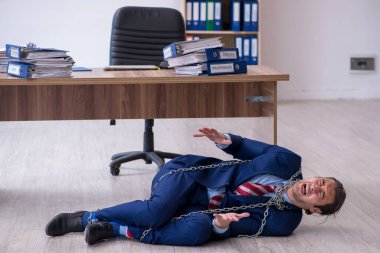 Zincirli erkek çalışanlar ofiste aşırı çalışmaktan memnun değiller.