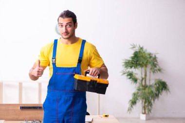 Genç erkek marangoz içeride çalışıyor.